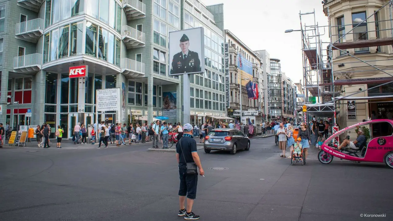 The Checkpoint Charlie in Berlin. The big glowing image shows an American or a Soviet soldier, depending on which side you are standing.