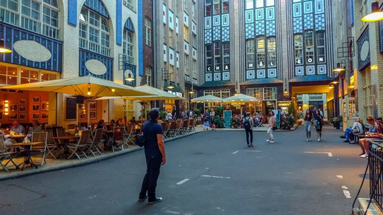 In the Summer bustle, people are sitting outside in front of the restaurants around the Hackesche Höfe in Berlin.